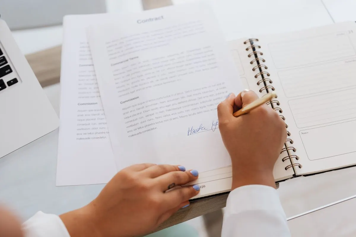 Close-up of hands signing a company resolution document on a desk